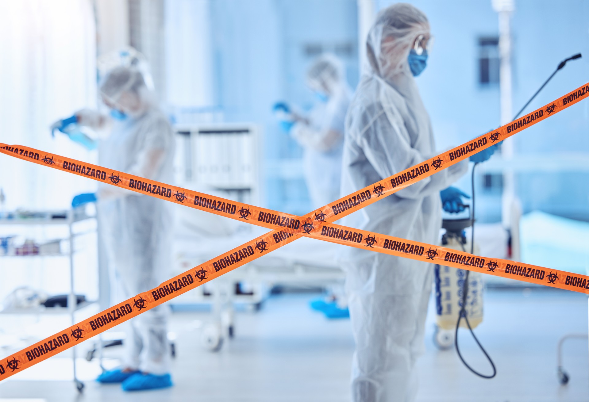 Biohazard team cleaning a hospital room. Science colleagues santise a hospital together. Medical team using antiseptic to sterilise a room. Biochemist cleaning a hospital together